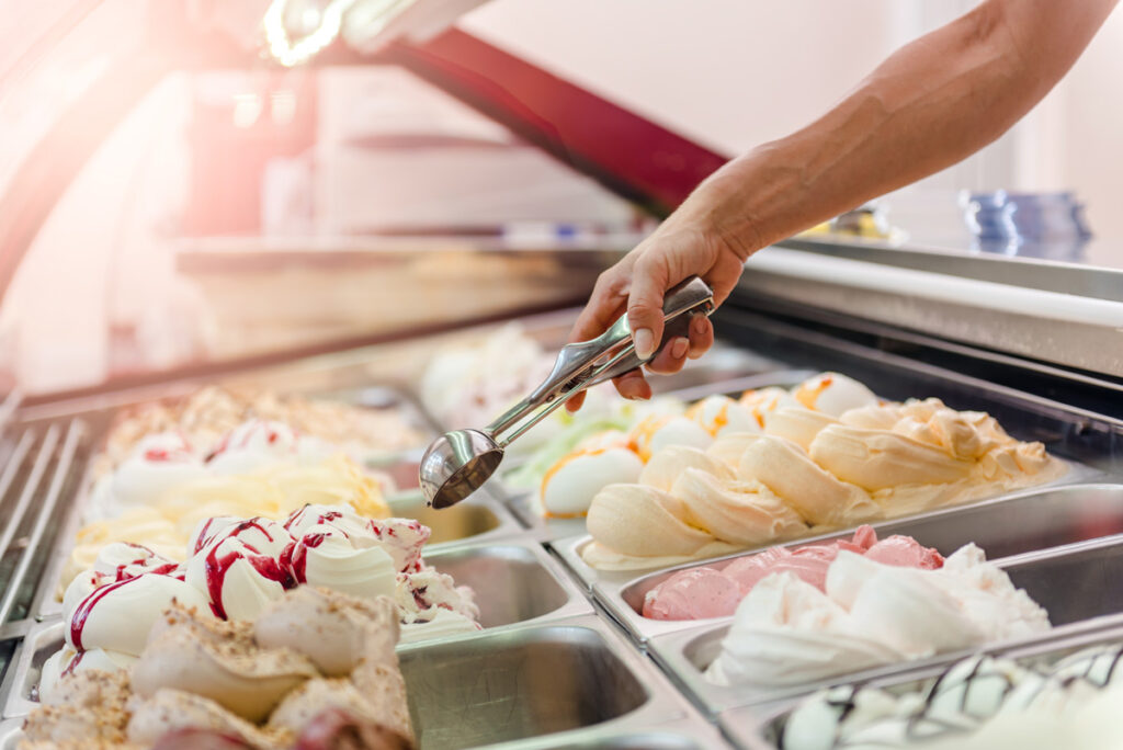 A person scooping ice cream out of a case in Norman.
